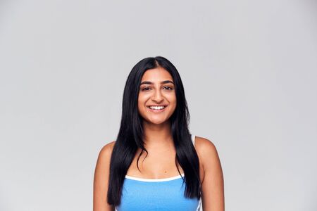 Studio Portrait Of Positive Happy Young Woman Smiling At Camera
