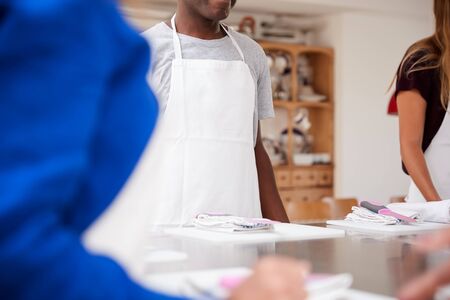 Close Up Of Male And Female Students With Chopping Boards At Start Of Cookery Class In Kitchenの写真素材