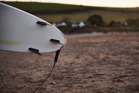 Close Up Of Underside Of Surfboard With Sandy Beach In Backgroundの写真素材