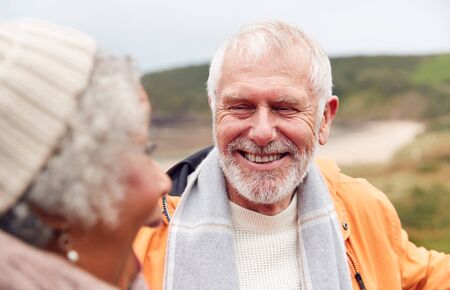 Close Up Of Loving Active Senior Couple Taking A Break As They Walk Along Coastal Path In Winter