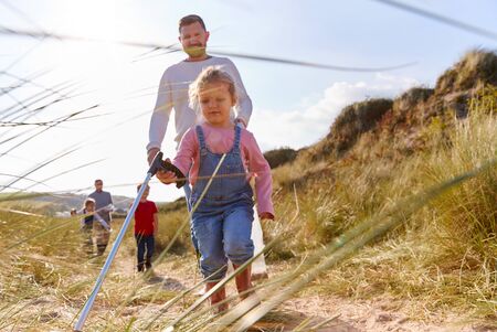 Multi-Generation Family Collecting Litter On Winter Beach Clean Upの写真素材