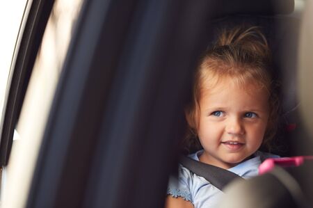 Young Girl Watching Digital Tablet In Back Seat On Car Journey