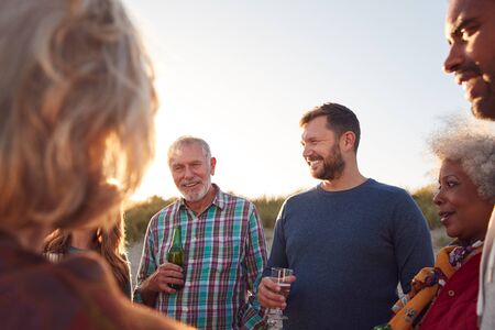 Multi-Generation Adult Family Celebrating With Wine On Winter Beach Vacation