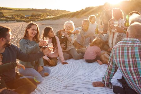 Multi-Generation Family Making A Toast With Alcohol On Winter Beach Vacation