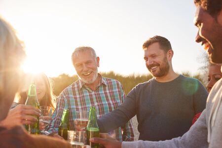 Multi-Generation Adult Family Celebrating With Wine On Winter Beach Vacationの写真素材