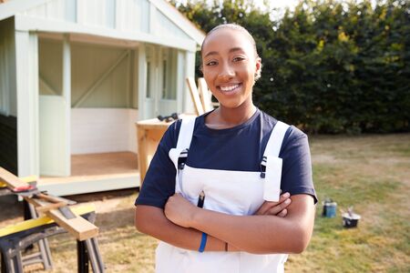 Portrait Of Female Carpenter Building Outdoor Summerhouse In Gardenの写真素材