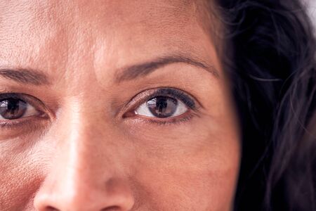 Close Up On Eyes Of Smiling Mature Woman In Studio