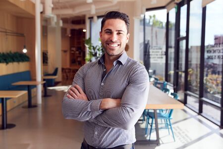 Portrait Of Businessman Standing In Modern Open Plan Officeの写真素材