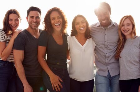 Portrait Of Group Of Multi-Cultural Friends Outdoors Against Flaring Sun
