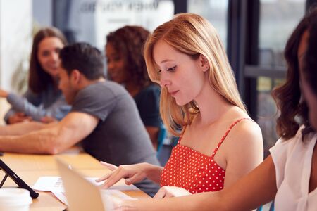 Businessmen And Businesswomen Working In Shared Open Plan Office Workspace