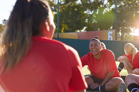 Womens Football Team Stretching Whilst Training For Soccer Match On Outdoor Astro Turf Pitchの写真素材