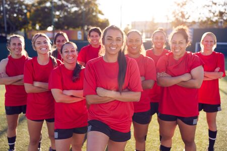 Portrait Of Smiling Womens Football Team Training For Soccer Match On Outdoor Astro Turf Pitchの写真素材