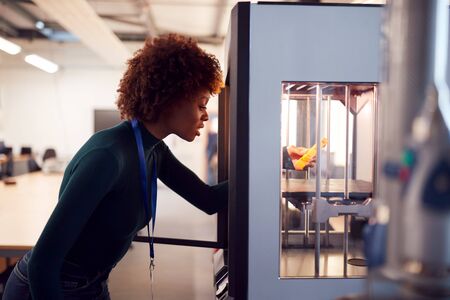 Female College Student Studying Engineering Using 3D Printing Machine