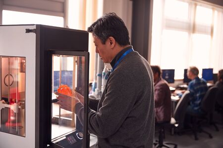 Mature Male College Student Studying Engineering Using 3D Printing Machineの写真素材