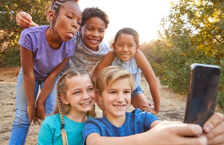 Group Of Multi-Cultural Children Posing For Selfie With Friends In Countryside Together