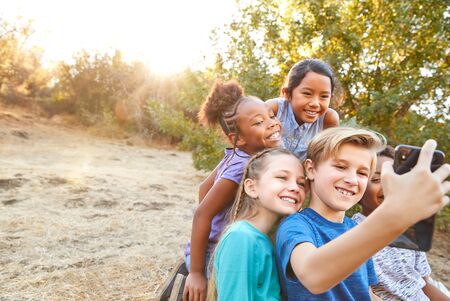Group Of Multi-Cultural Children Posing For Selfie With Friends In Countryside Togetherの写真素材