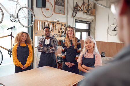Multi-Cultural Team In Workshop Assembling Hand Built Sustainable Bamboo Bicycle Frameの写真素材