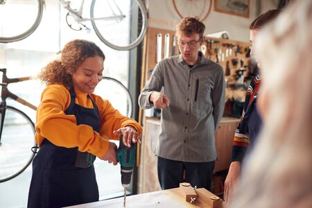 Multi-Cultural Team In Workshop Unpacking And Assembling Hand Built Sustainable Bamboo Bicycle Frameの写真素材