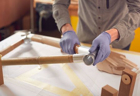 Close Up Of Male Craftsman In Workshop Assembling Hand Built Sustainable Bamboo Bicycle Frame