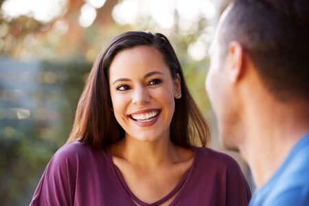 Smiling Hispanic Couple Talking And Laughing In Garden At Homeの写真素材
