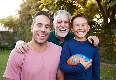 Portrait Of Multi-Generation Male Hispanic Family In Garden Smiling At Cameraの写真素材