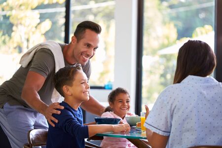 Hispanic Family Sitting Around Table Eating Breakfast Togetherの写真素材