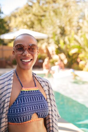 Portrait Of African American Woman With Shaved Head Outdoors With Friends Enjoying Summer Pool Party