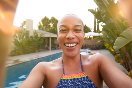 Young Woman At Summer Pool Party Taking Selfie On Mobile Phoneの写真素材