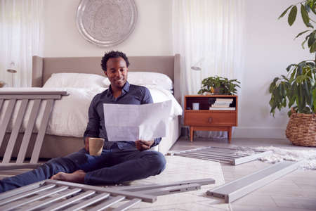 Father To Be Looking At Instructions For Self Assembly Baby Cot In Bedroomの写真素材