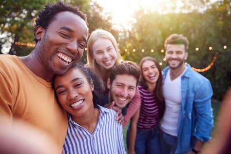 Group Of Multi-Cultural Friends Posing For Selfie As They Enjoy Outdoor Summer Garden Partyの写真素材