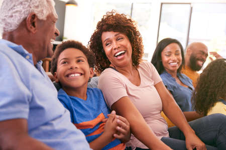 Multi-Generation African American Family Relaxing At Home Sitting On Sofa Watching TV Togetherの写真素材