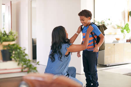 Mother Saying Goodbye To Son As He Leaves Home For Schoolの写真素材