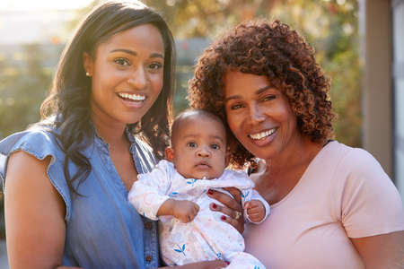 Portrait Of Grandmother With Adult Daughter And Baby Granddaughter In Garden At Home Togetherの写真素材