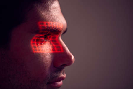 Facial Recognition Technology Concept As Man Has Red Grid Projected Onto Eye In Studioの写真素材