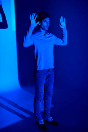 Studio Shot Of Man With Body Illuminated By Blue Light