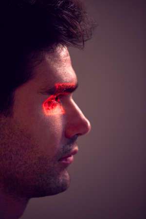 Facial Recognition Technology Concept As Man Has Red Grid Projected Onto Eye In Studioの写真素材
