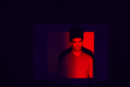 Studio Shot Of Man With Face Illuminated By Red Light