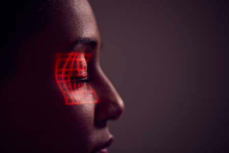 Facial Recognition Technology Concept As Woman Has Red Grid Projected Onto Eye In Studioの写真素材