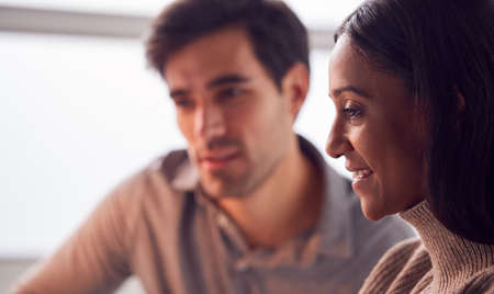 Close Up Of Businesswoman Working On Laptop At Desk Collaborating With Male Colleagueの写真素材