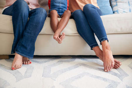 Close Up Of Multi-Generation Female Hispanic Family Sitting On Sofa At Homeの写真素材