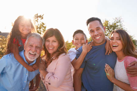 Portrait Of Multi-Generation Hispanic Family Relaxing In Garden At Home Togetherの写真素材