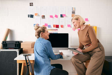 Two Women Running Creative Business In Studio Working At Desk Togetherの写真素材