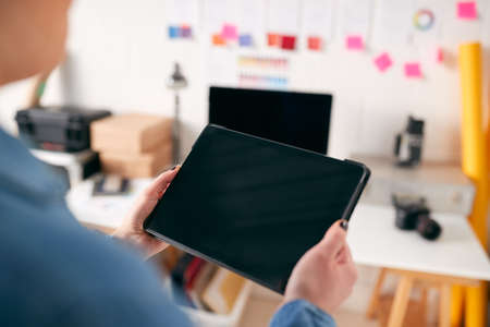 Close Up Of Businesswoman Using Tablet Computer In Studio Of Start Up Creative Businessの写真素材