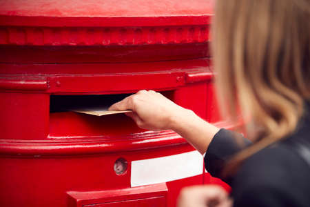 Close Up Of Businesswoman Posting Letter Into City Mailbox