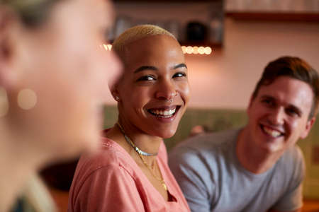 Group Of Friends Meeting At Home Having Fun Socializing Together
