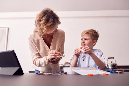 Grandson With Grandmother Assembling Electronic Components To Build Robot Together At Homeの写真素材