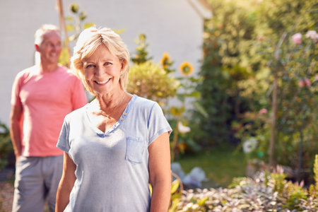 Portrait Of Retired Couple Working In And Enjoying Summer Garden At Homeの写真素材