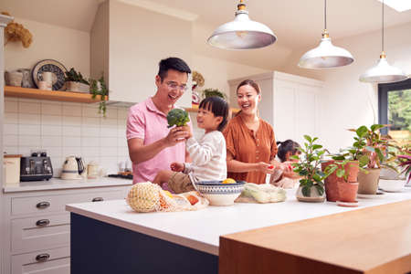 Asian Family Unpacking Local Food In Zero Waste Packaging From Bag In Kitchen At Homeの写真素材