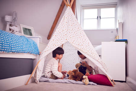 Asian Children In Tent Having Fun Playing With Toys In Bedroom Togetherの写真素材