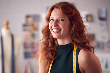 Portrait Of Female Student Or Business Owner With Tape Measure Working In Fashion Sitting On Deskの写真素材